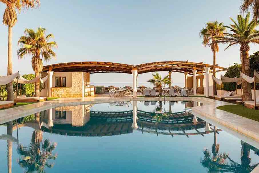 Πισίνα ξενοδοχειακού συγκροτήματος με καθρέφτισμα νερού σε ημέρα