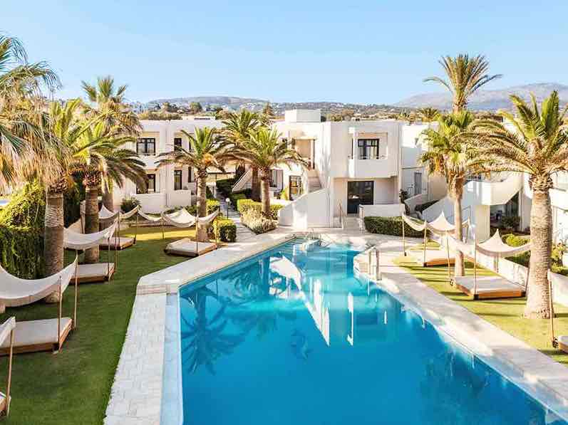 Πισίνα resort σε ηλιοβασίλεμα με θερμή ατμόσφαιρα και χρώματα ουρανού